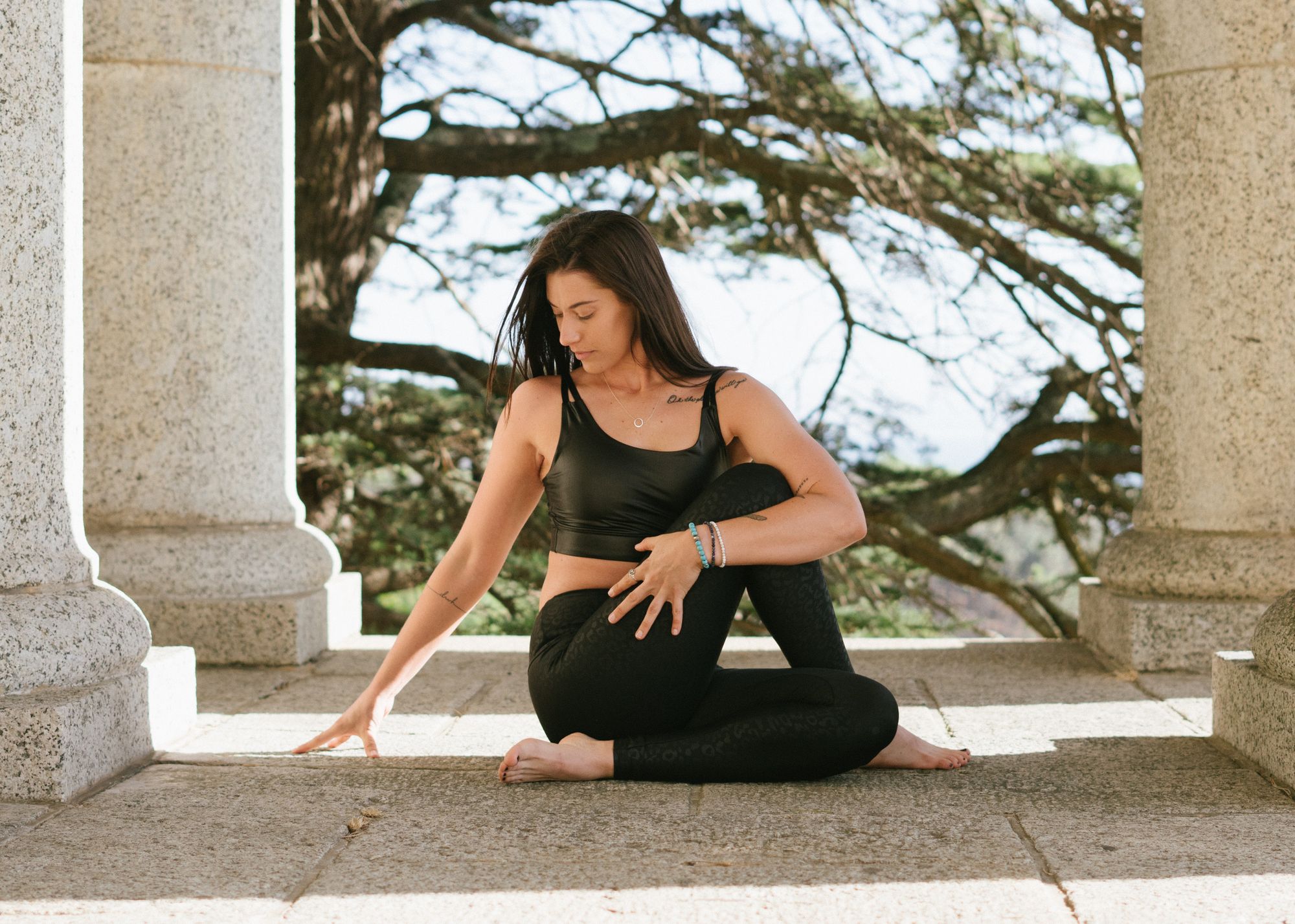 Woman in yoga position between stone columns 